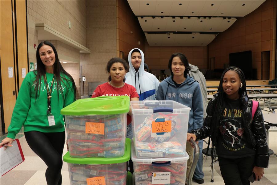 Casey and students pose with bins of food